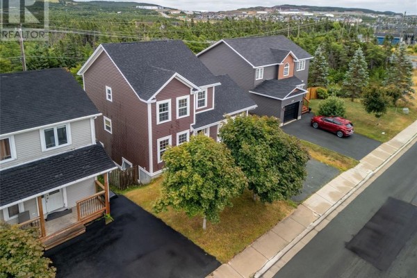 Aerial view of a suburban neighborhood with multiple houses and a red car. - 331 Stavanger Drive, St  John S