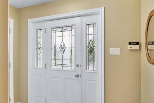 Interior view of a white front door with frosted glass side panels and a mirror. - 331 Stavanger Drive, St  John S