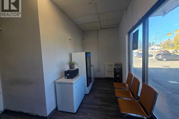 Waiting area with orange chairs facing large front windows. - 3315 26 Avenue Sw, Calgary