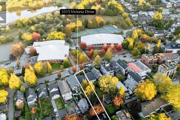 Aerial view showing 3315 Victoria Drive, a home next to a park with a pond, tennis courts, and school buildings. - 3315 Victoria Drive, Vancouver