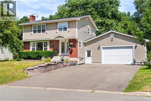 Front exterior of a beige two-story house with a brick accent and attached garage viewed from driveway. - 332 Mcallister Road, Riverview