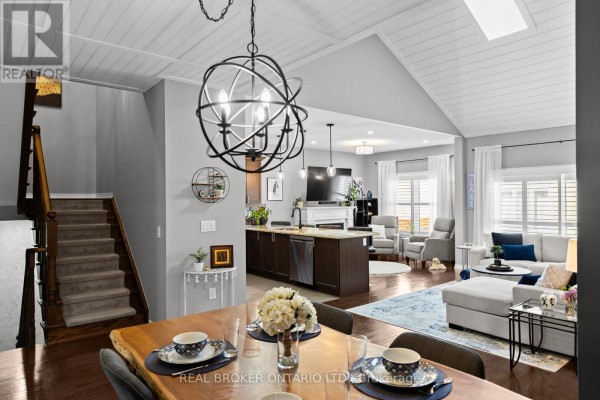 Dining area with a live-edge table and chairs, open to a living room with a grey sectional sofa. - 3321 Beach Club Boulevard, Severn