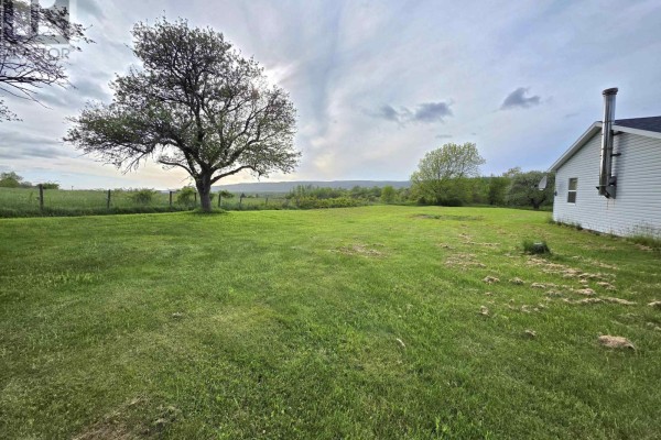 Expansive grassy field with trees and a white house in the distance. - 3321 Highway 201, Centrelea