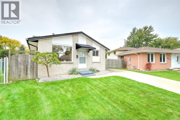 Front view of the bungalow with a well-kept lawn and concrete driveway. - 3325 Dolphin Court, Windsor