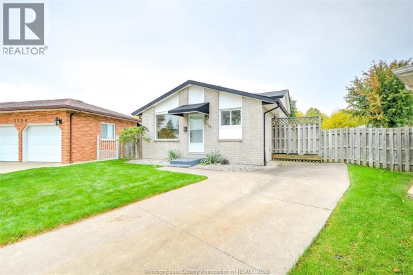 Side view of the bungalow, showing the driveway and neighboring property. - 3325 Dolphin Court, Windsor