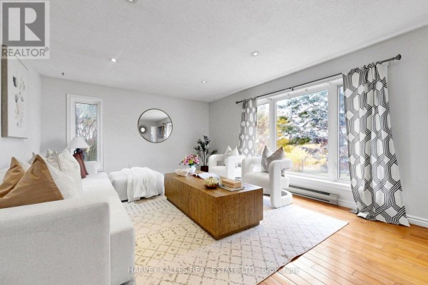 Bright living room with large windows, white sofa, coffee table, and patterned curtains. - 3327 Simcoe County 50 Road, Adjala Tosorontio