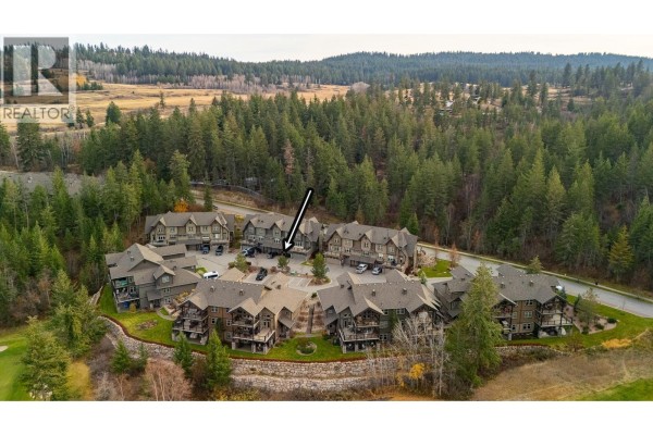 Aerial view highlighting the townhouse layout amidst forested area. - 333 Longspoon Drive Unit# 33, Vernon