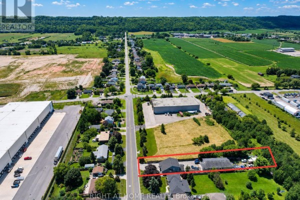 Aerial view of the property outlined in red, situated on a road with fields and industrial buildings. - 333 Mcneilly Road, Hamilton