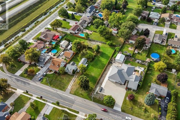 Aerial view of the land parcel's 'L' shape, bordered by fences, with suburban homes and a street nearby. - 333 Victoria Street, Essex