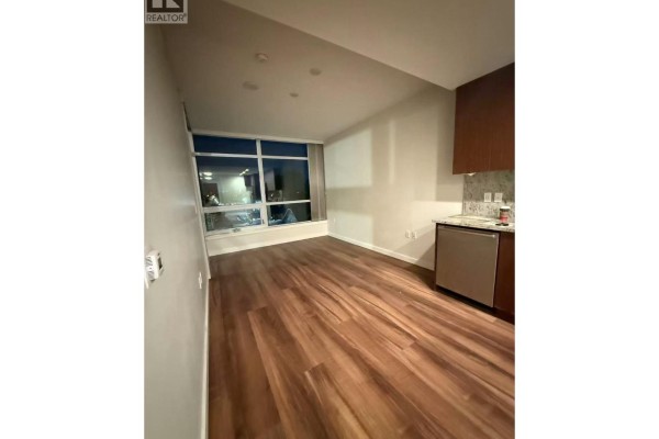 Living area adjacent to the kitchen with large windows and wood flooring. - 3333 Sexsmith Road, Richmond