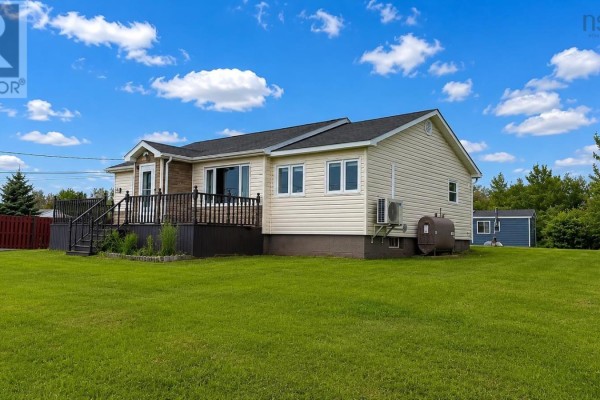 Side view of a beige vinyl sided bungalow with a dark wood deck, propane tank and outdoor air conditioner. - 334 Park Road, Florence