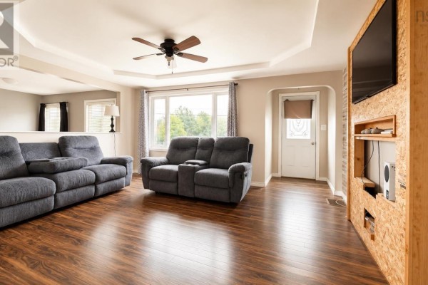 Living room with grey reclining sofas, dark wood laminate flooring, and a large window with grey curtains. - 334 Park Road, Florence