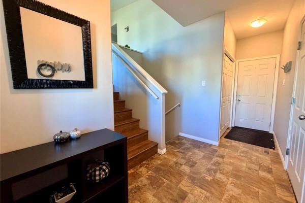 Another view of the home entrance, featuring wood stairs, a large mirror, and doors to other rooms. - 335 6th Avenue, Oakville