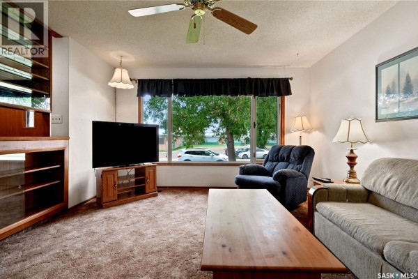 Living room with furniture, television, and window overlooking the street. - 335 Broad Street, Lumsden