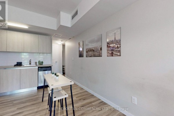 Compact kitchen with stainless steel appliances, light wood cabinetry, and gray countertops. - 335 College Street, Toronto