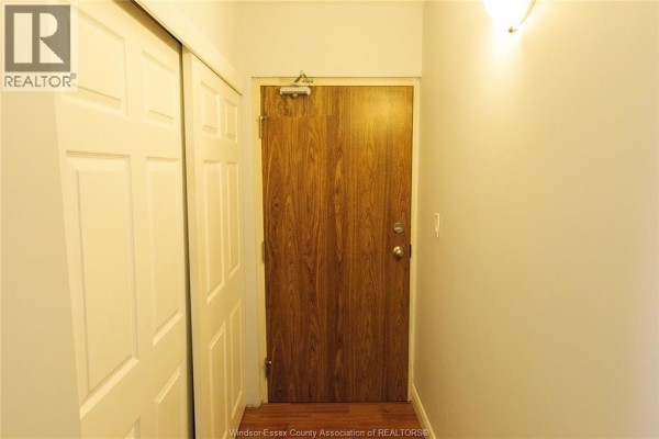 Interior view of a hallway with a wooden door and closet. - 3355 Sandwich Unit# 310, Windsor