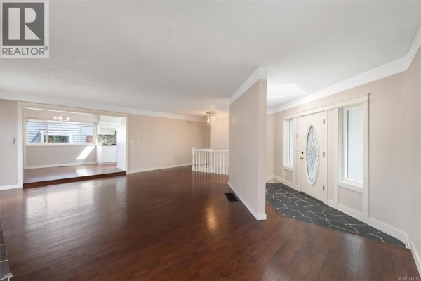 View from the living room showing the entrance foyer with a decorative door and adjacent dining area. - 336 Stannard Ave, Victoria
