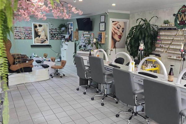 Nail salon featuring manicure stations, pedicure chairs, and decorative cherry blossom branches. - 336 Weston Road, Toronto