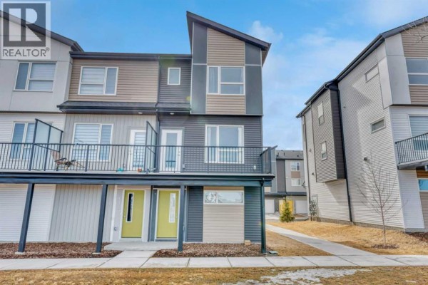 Front exterior of a modern townhouse with grey siding and a balcony. - 337, 301 Redstone Boulevard Ne, Calgary