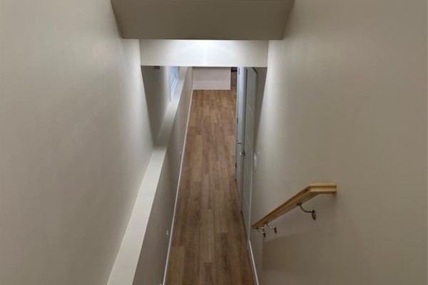 View down a hallway with wood-look vinyl flooring and neutral walls. - 3371 Byng Unit# 2, Windsor