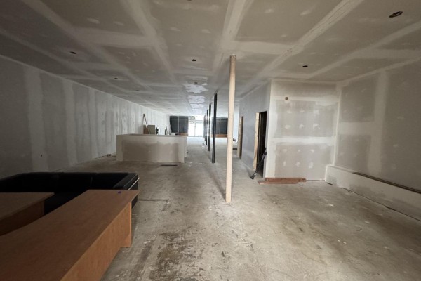 Long, unfinished interior commercial space with drywall walls, concrete floor, and some furniture. - 33719 Essendene Avenue, Abbotsford