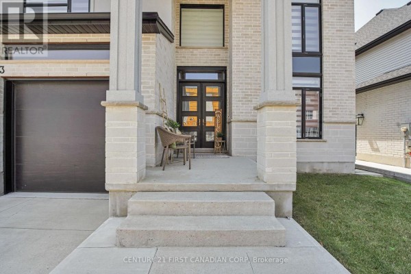 Close-up of the house entrance with two pillars, a small seating area, and double doors. - 3373 Regiment Road, London South