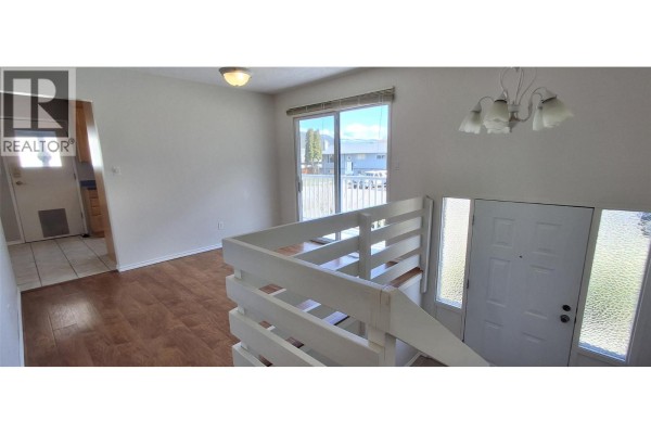 Aerial view of a backyard with a large green lawn, garden beds, and a shed. - 338 Beach Drive, Chase