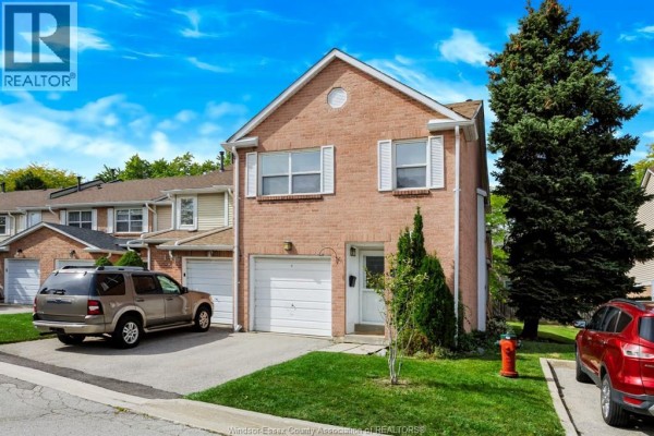 Close-up of the brick exterior, white garage door, and front entrance of the townhouse. - 3380 South Millway Unit# 44, Mississauga