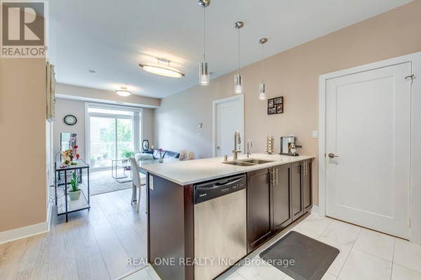 Open concept kitchen and living area with balcony visible through sliding glass doors. - 339 - 28 Prince Regent Street, Markham