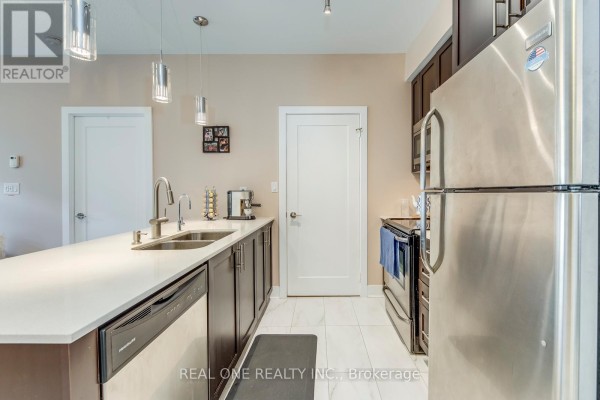 Kitchen island with sink and dishwasher, stainless steel refrigerator, and dark cabinets. - 339 - 28 Prince Regent Street, Markham