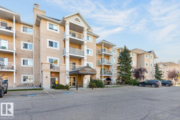 Main entrance of the Promenade West apartment building with surrounding parking and landscaping. - #339 17447 98a Av Nw, Edmonton
