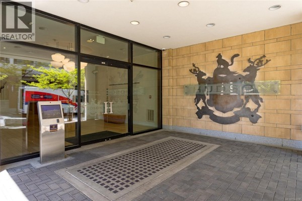 Entrance to the building with a large metal crest and glass doors. - 339 770 Fisgard St, Victoria