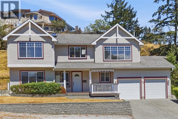 Close-up of the front entrance to a beige house, featuring a white door with glass, a covered porch, and lush greenery. - 339 Nottingham Dr, Nanaimo