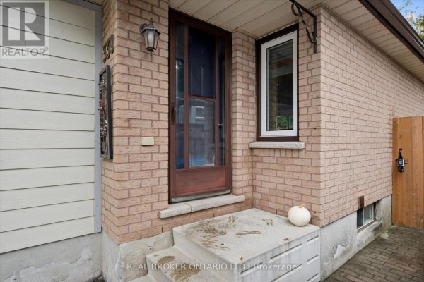 Entrance to the house with a brick facade, wooden door, and concrete steps. - 339 Strathallan Street, Centre Wellington