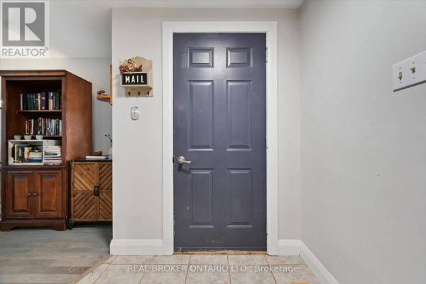 Interior view of a hallway with a grey door and a wooden cabinet. - 339 Strathallan Street, Centre Wellington