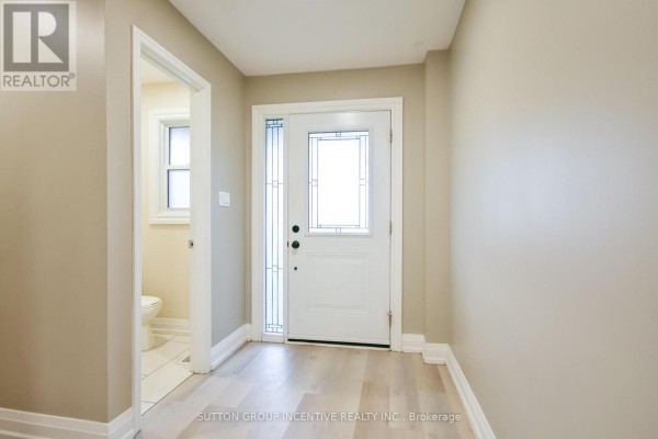 The front entryway features a white door with frosted glass sidelights and a beige door opening to a powder room. - 33b Cundles Road E, Barrie