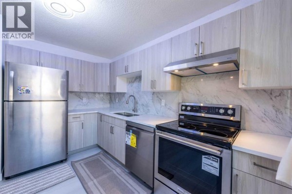 Side view of townhouse with clear sky and minimal snow - 34, 3029 Rundleson Road Ne, Calgary
