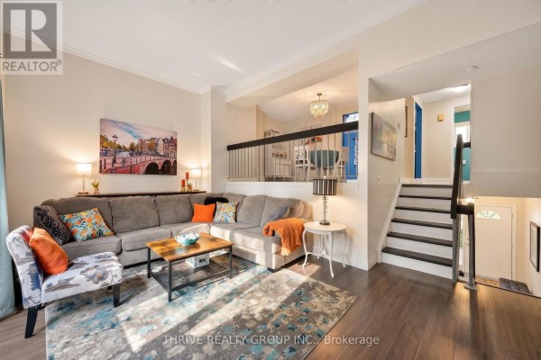 Living room with a sectional sofa, coffee table, armchair, and a view of stairs. - 34 - 300 Sandringham Crescent, London South