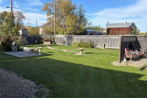 Spacious backyard with seating areas, bird baths, stone pathways, and a fence. - 34 1st Street N, St Benedict