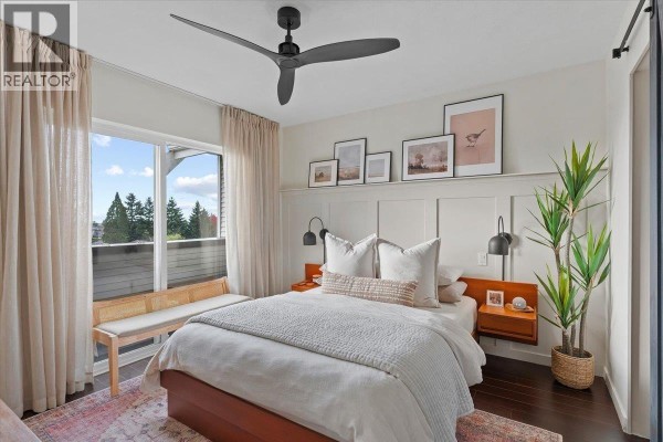 Bedroom with a large window, king-size bed, and a bench at the foot of the bed. - 34 7370 Stride Avenue, Burnaby