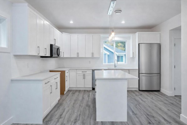 Open-concept living area with kitchen island, large windows, and fireplace - 34 750 Hot Springs Road, Harrison Hot Springs, Harrison Hot Springs