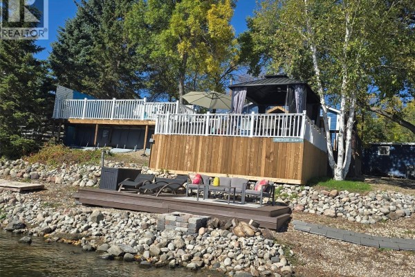 Rear view of the property showcasing decks, an outdoor seating area, and a gazebo by the lake. - 34 Bear Road, Crooked Lake