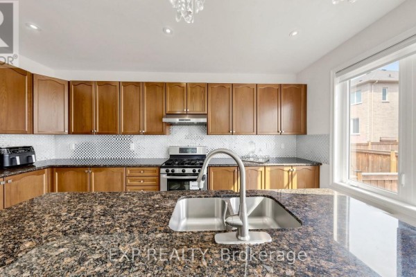 Kitchen with wood cabinets, granite countertops, gas range, and large window - 34 Buttonleaf Crescent Whitchurch Stouffville