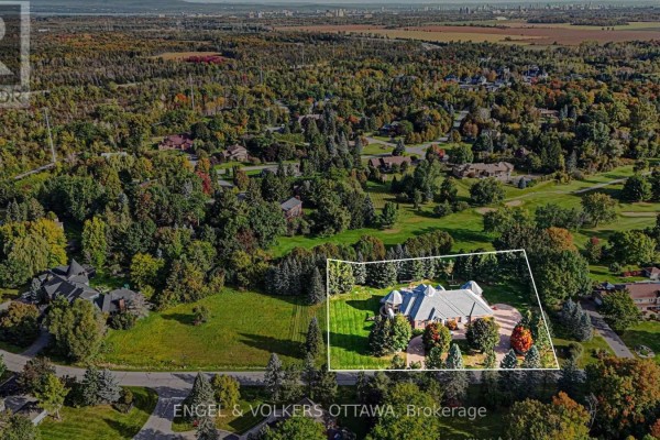 Aerial view showing a large property with a house outlined in white, amidst mature trees and landscape. - 34 Cedarhill Drive, Ottawa