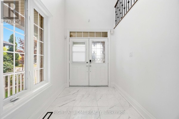 Foyer with white walls, double entry doors with decorative glass, and marble tile flooring. - 34 Dring Street, Ajax