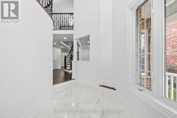 View of the foyer, staircase with black spindles, and an adjacent hallway. - 34 Dring Street, Ajax