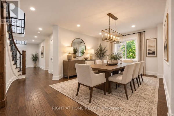 Dining room with a large wooden table, upholstered chairs, sideboard, and a chandelier. - 34 Dring Street, Ajax