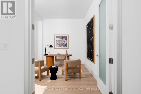 Home office with a desk, chairs, and artwork on white walls. - 34 Edgecroft Road, Toronto