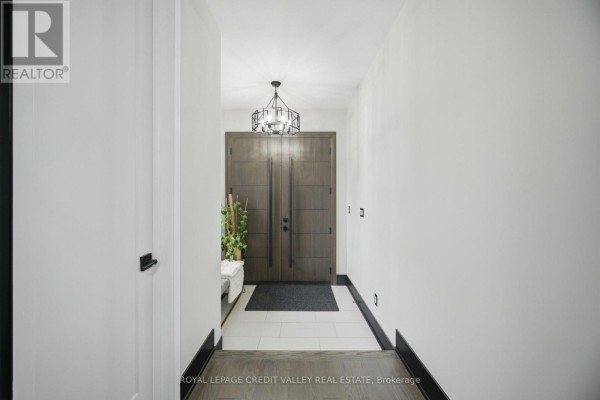Foyer with white walls, dark wood double doors, and a modern geometric chandelier. - 34 Felhazi Trail S, Essa