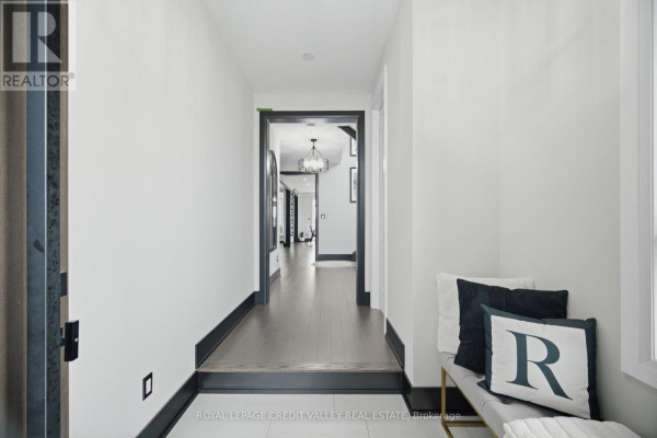 Interior hallway with dark wood floors, white walls, and a view into other rooms. - 34 Felhazi Trail S, Essa